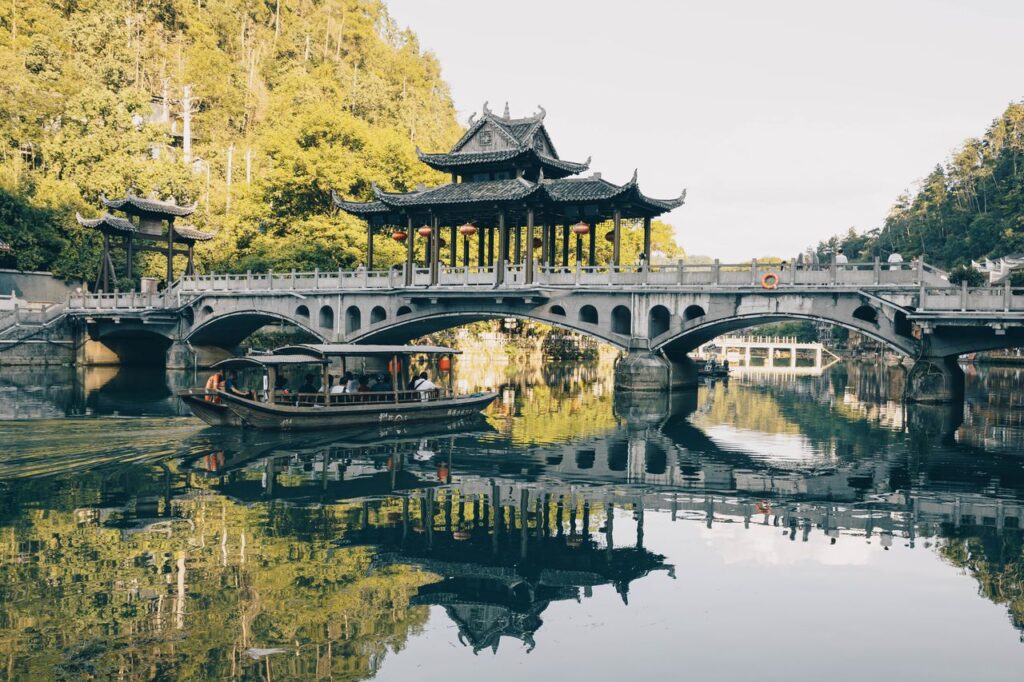 Beautiful traditional Chinese bridge over a reflective lake with lush surroundings.